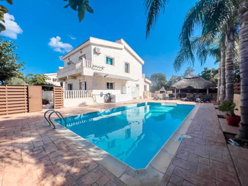 a villa with a swimming pool in front of a house at FAME villa with Private Pool and Gazebo in Ayia Napa