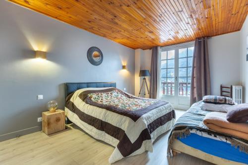 - une chambre avec deux lits et un plafond en bois dans l'établissement Chalet Les Noisetiers, à Saint-Lary-Soulan