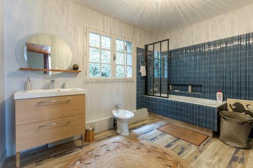 La salle de bains est pourvue d'un lavabo, d'une baignoire et de toilettes. dans l'établissement Chalet Les Noisetiers, à Saint-Lary-Soulan