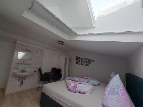 a small bedroom with a bed and a sink at Pension Alpengruss in Heiterwang