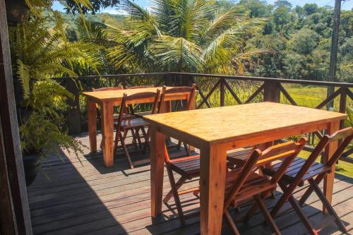 two wooden tables and chairs on a deck at Pousada e Bistrô Estância Monte Horebe in Mulungu