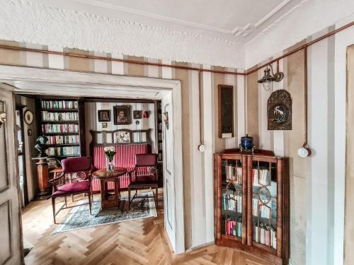 a living room with red chairs and a table at Divná pani Luxury Gallery Rooms in Banská Štiavnica