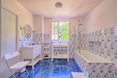 y baño con bañera y lavamanos. en Maison au calme grand jardin privé aire de jeux Lac de Guerledan en Plouguernével