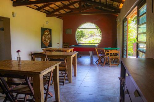 a restaurant with tables and chairs and a window at Pousada e Bistrô Estância Monte Horebe in Mulungu