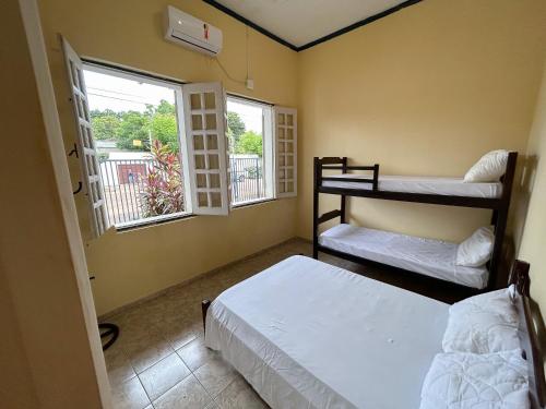 a bedroom with two bunk beds and two windows at Casarão Central in Carolina