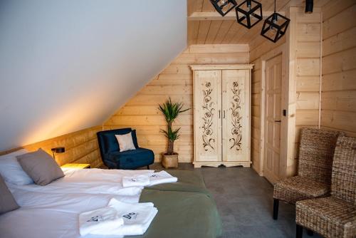 a bedroom with a bed and a chair and a door at Montana górska chata in Brenna