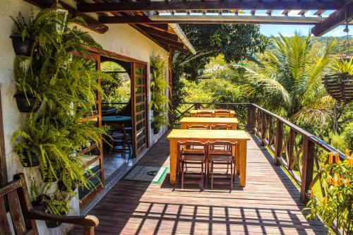 een houten terras met tafels en stoelen erop bij Pousada e Bistrô Estância Monte Horebe in Mulungu