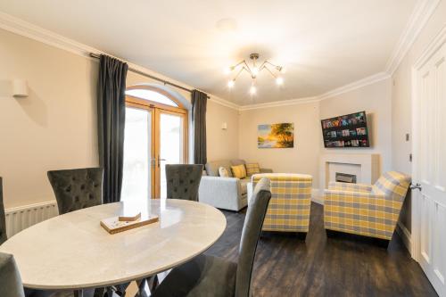 a dining room and living room with a table and chairs at Escape Ordinary at Castle Hume in Enniskillen