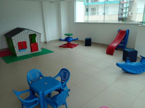 um quarto com um parque infantil com cadeiras e um escorrega em Apartamento na Praia Grande - Ubatuba em Ubatuba