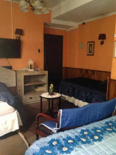 a hotel room with two beds and a television at Hotel La Castellana in Santiago