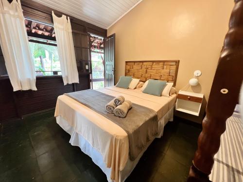 1 dormitorio con 1 cama con toallas en Pousada Paloma en Abraão