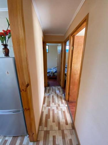a hallway leading to a room with a refrigerator at Cabaña III en ambiente familiar in Los Vilos