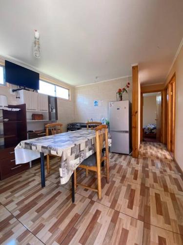 a kitchen with a table and a kitchen with a refrigerator at Cabaña III en ambiente familiar in Los Vilos