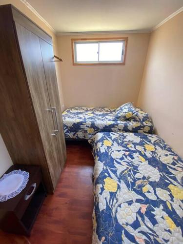 a small bedroom with two beds and a window at Cabaña III en ambiente familiar in Los Vilos