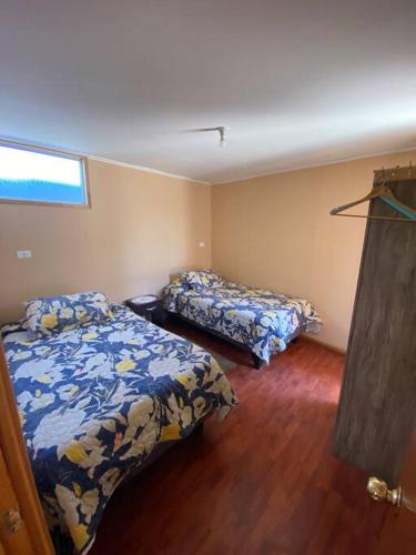 a bedroom with two beds and a window in it at Cabaña III en ambiente familiar in Los Vilos