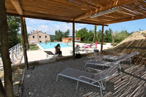 a patio with chairs and a swimming pool at The Cherry House, Apartamento Monterosa in Petritoli