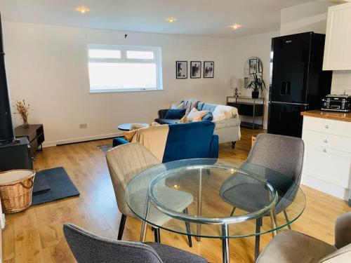 a living room with a glass table and chairs at 2Bed Annexe nr Vale Resort, Golf & Spa in Ystradowen