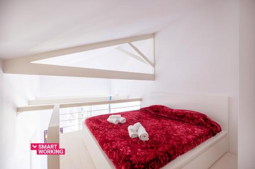a bedroom with a red bed with shoes on it at Belvedere Hambury Apartment by Wonderful Italy in Bordighera