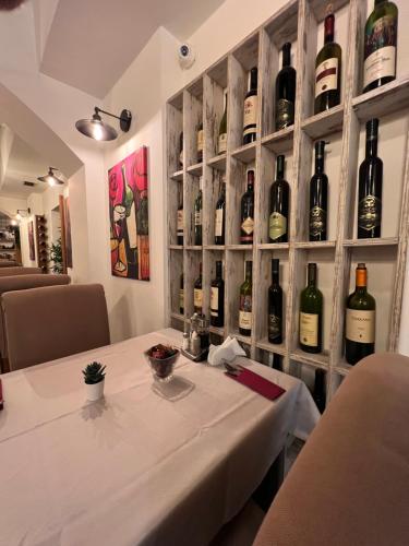 a dining room with a table and a wall of wine bottles at Capital Hotel Garni in Belgrade