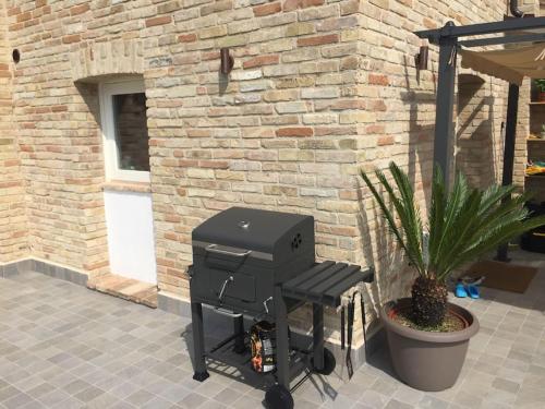 a grill sitting in front of a brick building at The Cherry House, Apartamento Monterosa in Petritoli