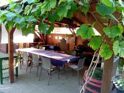 a table and chairs in a room with a tree at Árpád Ház in Alsónána