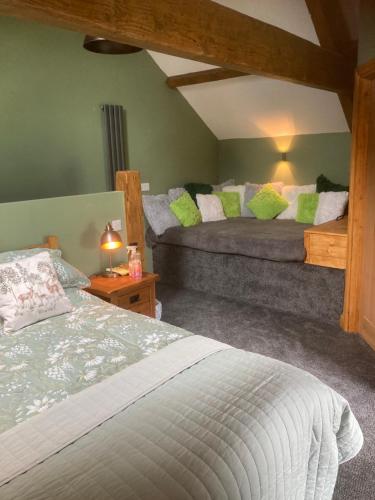 a bedroom with two beds with green pillows at Whiteside Granary in Haltwhistle