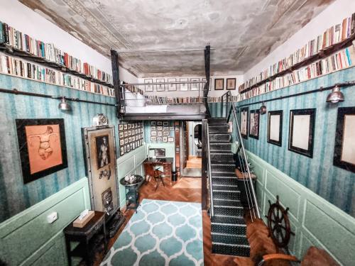 a staircase in a room filled with books at Divná pani Luxury Gallery Rooms in Banská Štiavnica