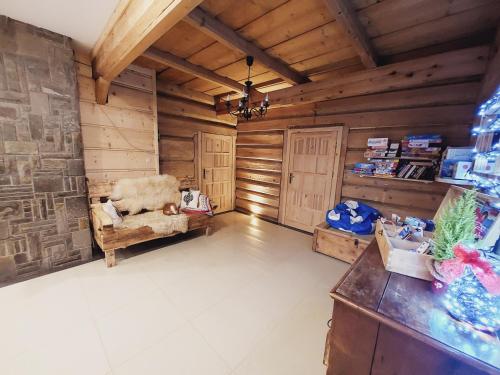 a living room with wooden walls and a chair at Domek, Apartamenty i pokoje Willa Elita in Kościelisko