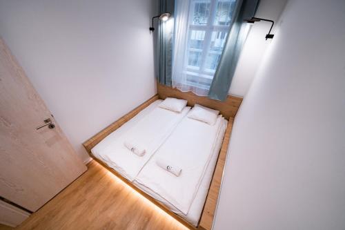 Habitación pequeña con ventana y 2 almohadas blancas. en Coente Apartments Király 28 en Budapest