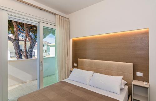 - une chambre avec un lit et une grande fenêtre dans l'établissement Sea Holidays Apartment, à Marina di Pietrasanta