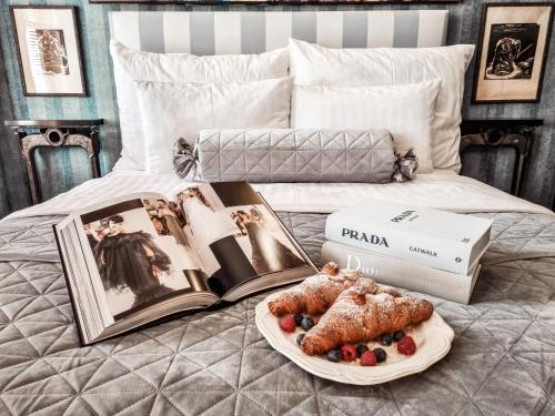 a tray of food on a bed with a plate of food at Divná pani Luxury Gallery Rooms in Banská Štiavnica