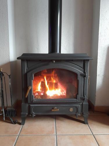 a stove with a fire in a room at Mulino Valsorda in Magnano