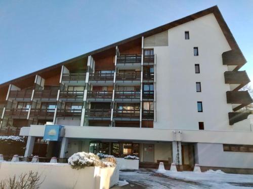 an apartment building with snow on the ground at Studio au pied des pistes in Enchastrayes