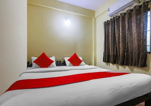 a bedroom with a large bed with red pillows at Ocean Way Guest House in Baga