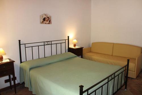 a bedroom with a bed and a couch at Agriturismo Sant'Agata in Piana degli Albanesi
