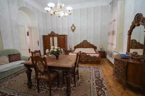 a bedroom with a table and a bed and a couch at Leon Rooms in Tbilisi City