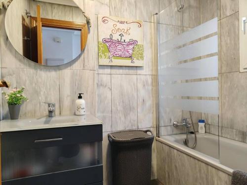 La salle de bains est pourvue d'un lavabo, d'un miroir et d'une baignoire. dans l'établissement APARTAMENTOS TURISTICOS SEVIRO Madrid, à Madrid
