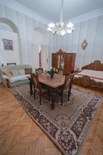 a living room with a table and a bed at Leon Rooms in Tbilisi City