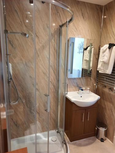 a bathroom with a shower and a sink at Grammar Lodge Guest House in Campbeltown