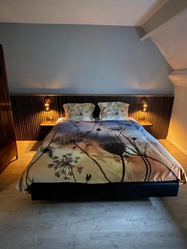 a bedroom with a large bed with two lamps at B&B Hof 't Sprakel in Haaksbergen