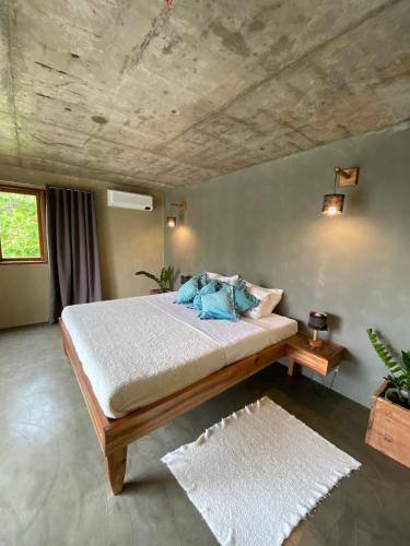a bedroom with a large bed and a wooden ceiling at Sampaguita Villas in El Nido