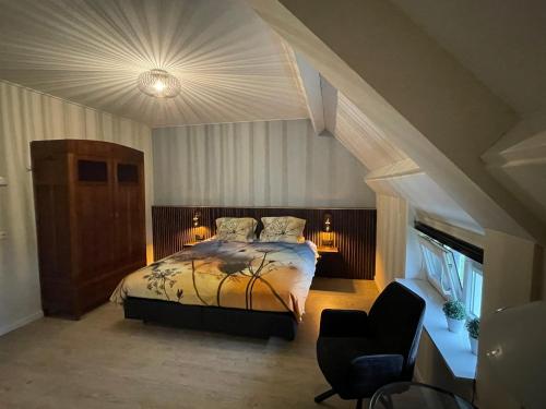 a bedroom with a bed and a chair at B&B Hof 't Sprakel in Haaksbergen