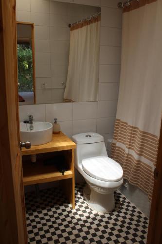 a bathroom with a white toilet and a sink at Acogedora casa a pasos de la playa-Couzy house next to the beach in La Serena