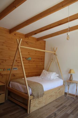 a bed in a room with wooden walls at Acogedora casa a pasos de la playa-Couzy house next to the beach in La Serena