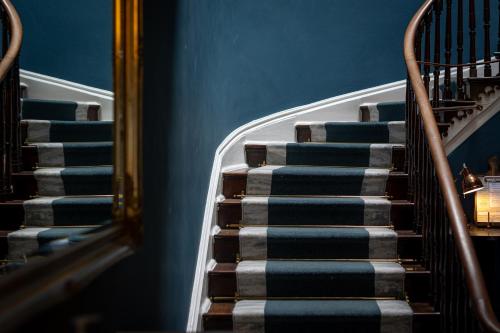 un conjunto de escaleras en un edificio con paredes azules en Hotel Plas Hyfryd, en Narberth
