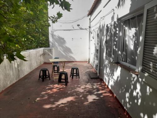 una mesa y dos taburetes sentados en un patio en Departamento 4 personas Colon 2900 en Mar del Plata