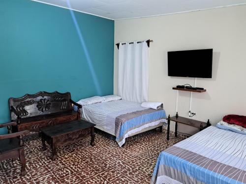 a room with two beds and a flat screen tv at Hostal Lima Verde in La Lima