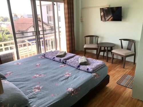 a bedroom with a bed with a view of a balcony at บ้านยายกิ้ว in Phra Nakhon Si Ayutthaya