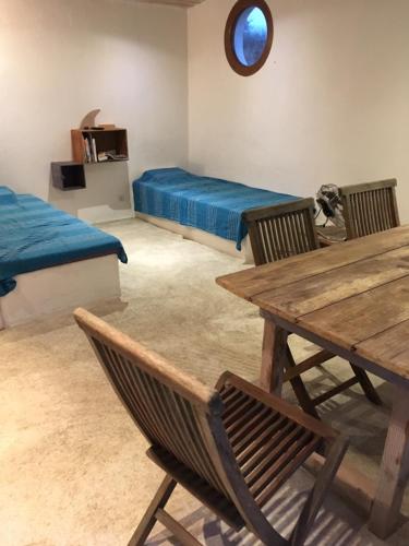 une chambre avec deux lits, une table et des chaises dans l'établissement La rose bleue (2), à Olmeto