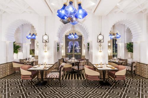 a dining room with tables and chairs and chandeliers at Fairmont La Marina Rabat Sale Hotel in Rabat